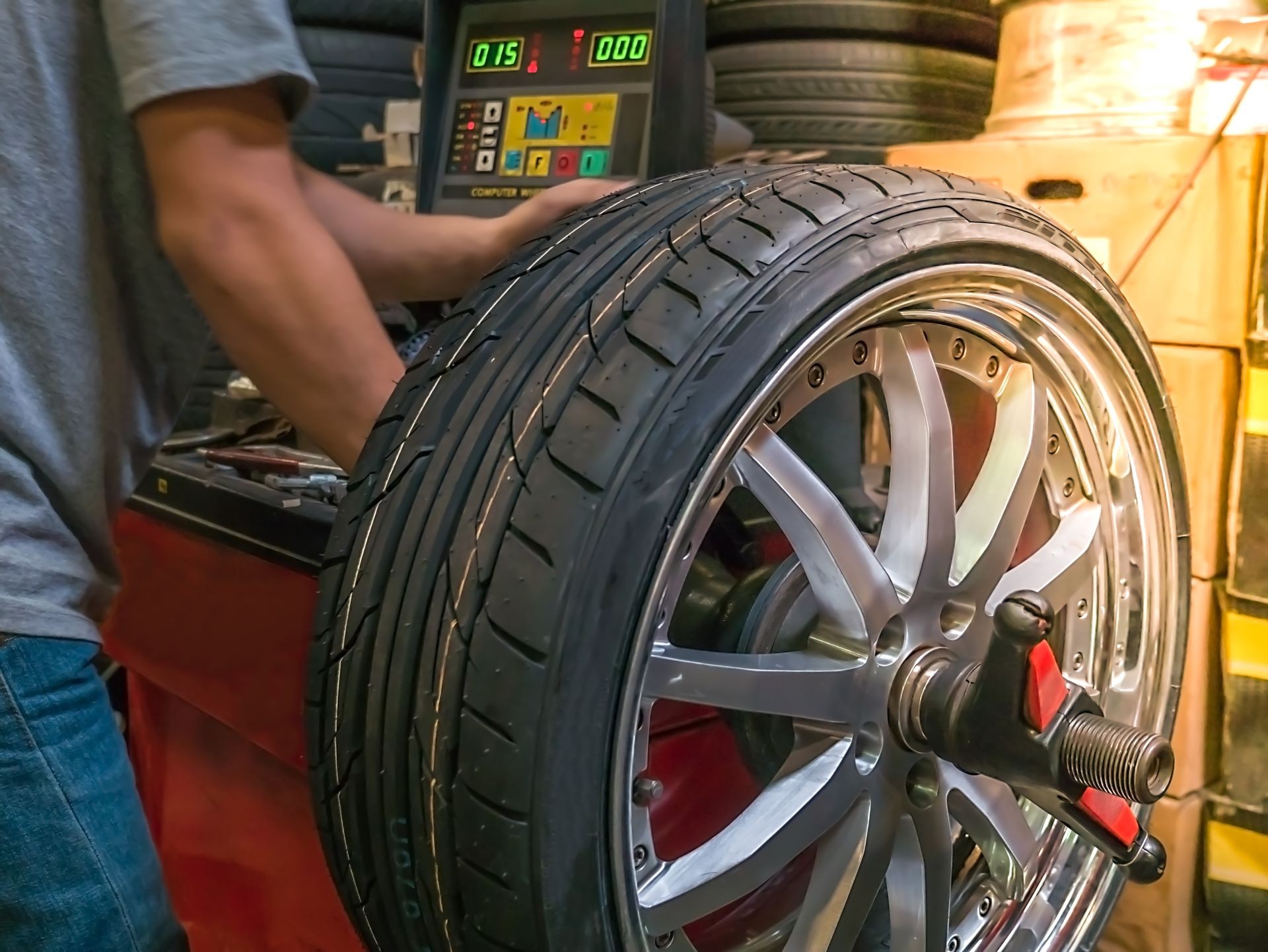 The mechanic using computerize wheel balancer to balance the wheel. Seletive focused The mechanic using computerize wheel balancer to balance the wheel. Seletive focused
